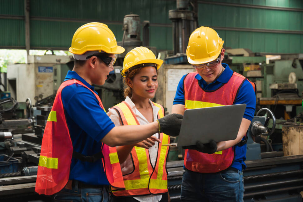 The industrial worker team is working on various projects in a large industrial factory with many equipment.