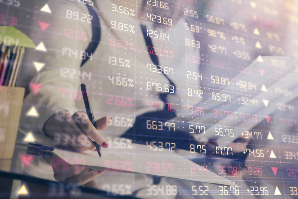 A woman hands writing information about stock market in notepad. Forex chart holograms in front. Concept of research.