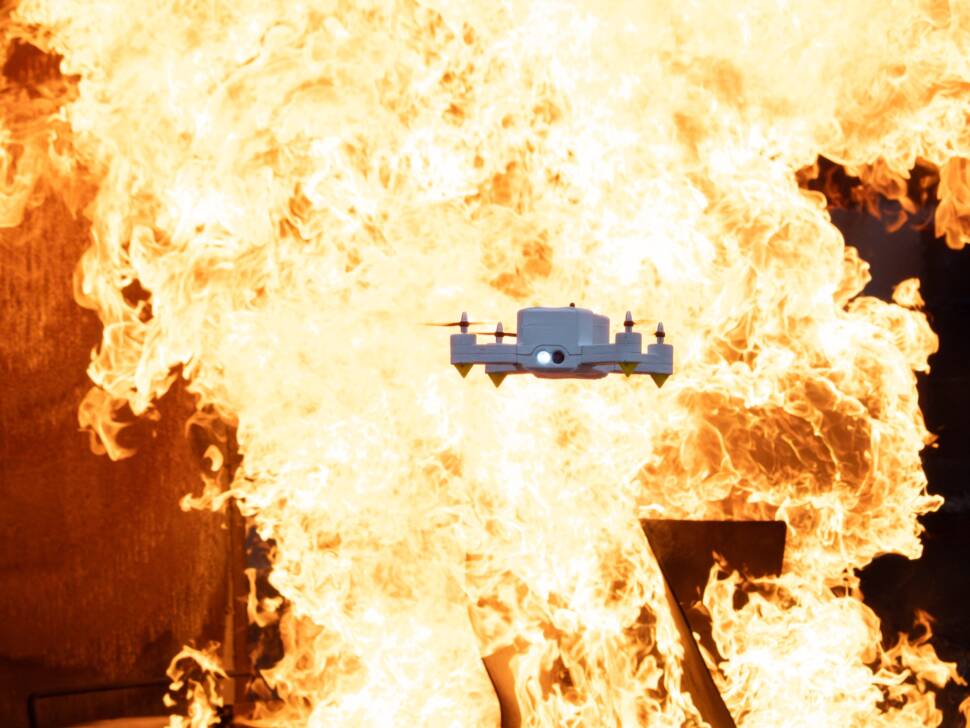 Die FireDrone kann auch in heißen Umgebungen fliegen. Das Bild zeigt sie vor einer Feuerwand.