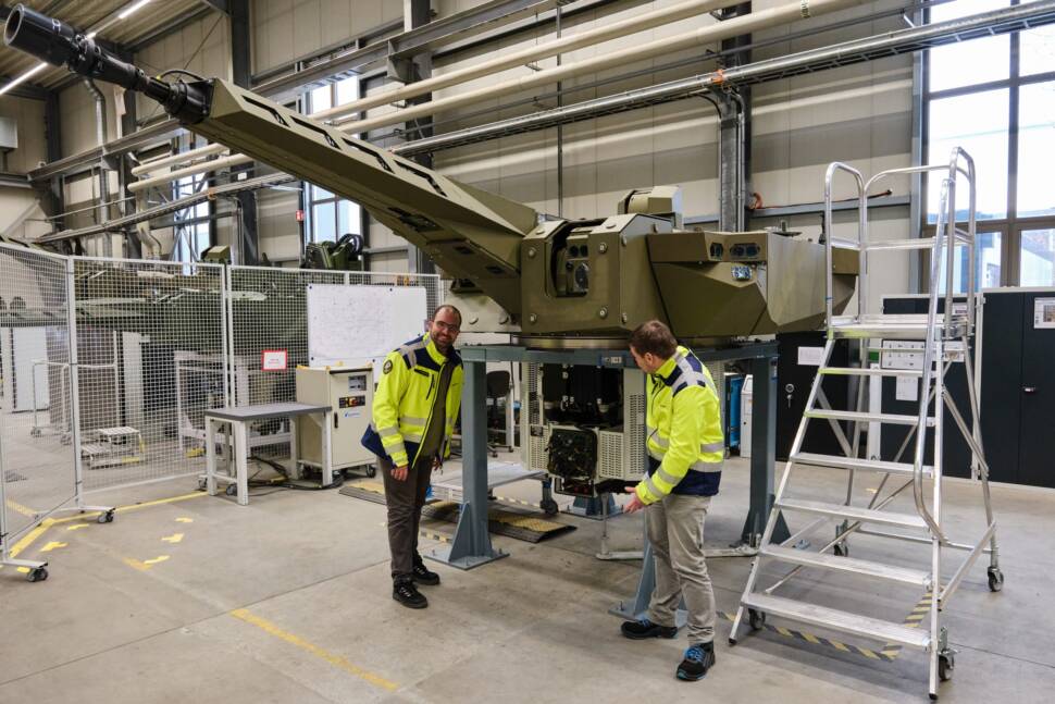Rheinmetall Ingenieur Christian Konrad (auf dem Bild links) vor einem Panzerturm.