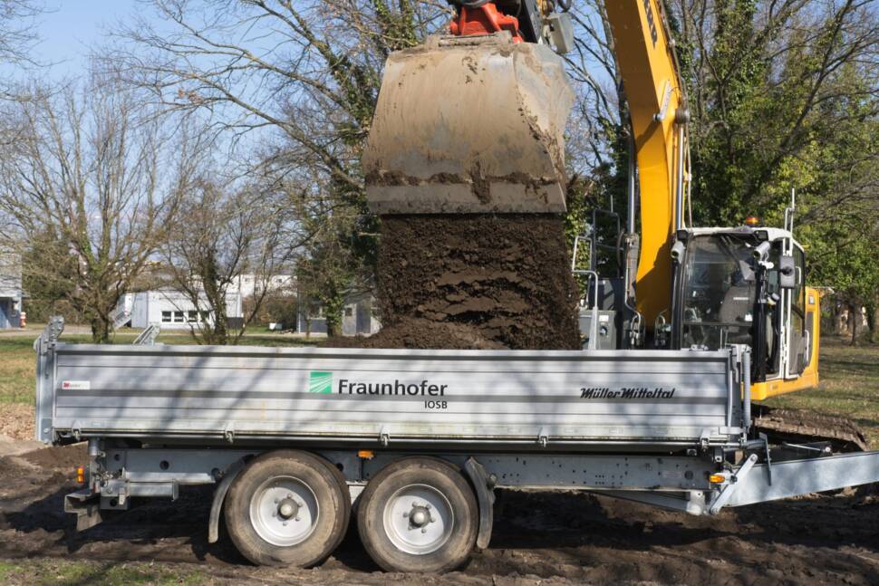 Am Fraunhofer IOSB in Karlsruhe sollen große Baumaschinen möglichst autonom miteinander interagieren. Das Bild zeigt einen Bager und einen Unimog mit Anhänger.