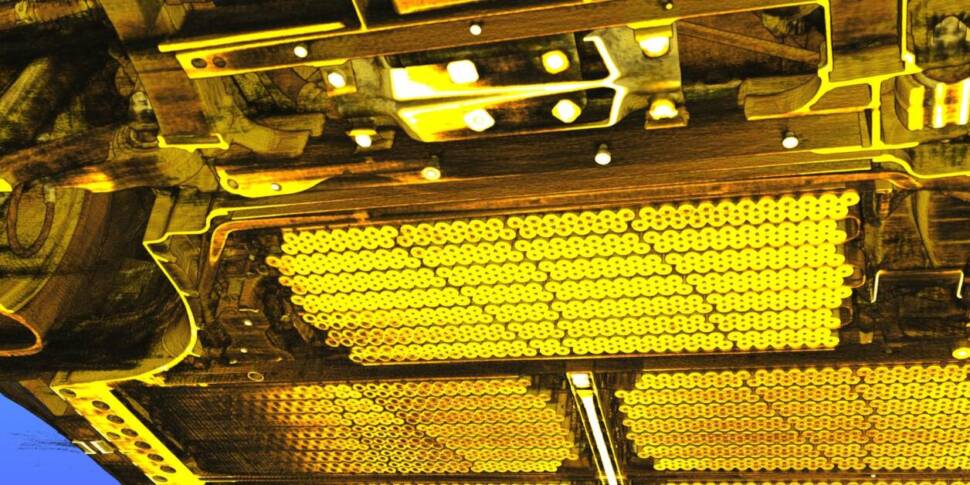 Unterboden eines Elektroautos mit Baterriemodulen in gelber Farbe angestrahlt.