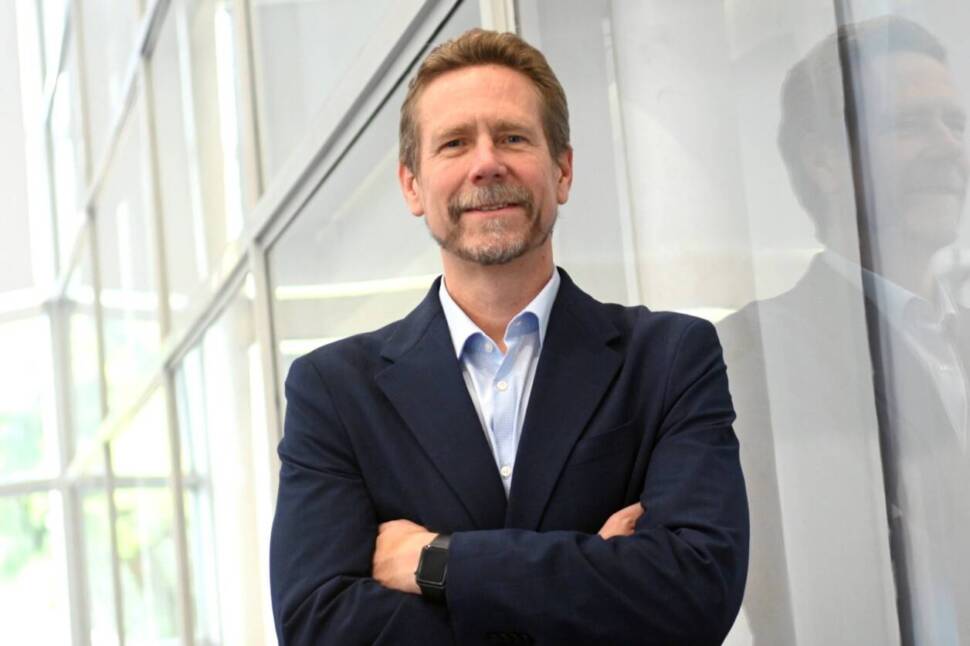 André Wulfhorst im dunklen Anzug vor einer Glasfasssade