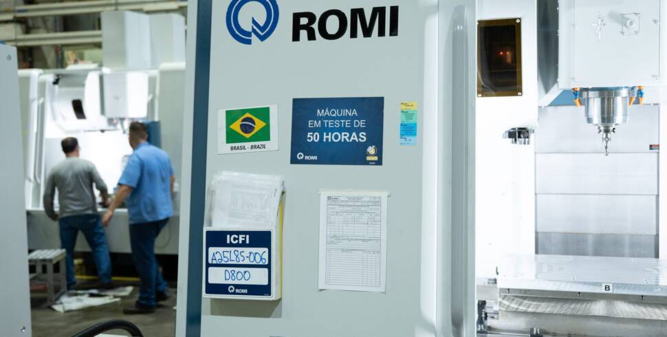 Blick in eine Werkzeugmaschinen in der Produktion von Romi mit Menschen im Hintergrund