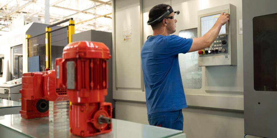 Mensch mit AR-Brille vor einer Werzeugmaschine zur Produktion von Antriebskomponenten