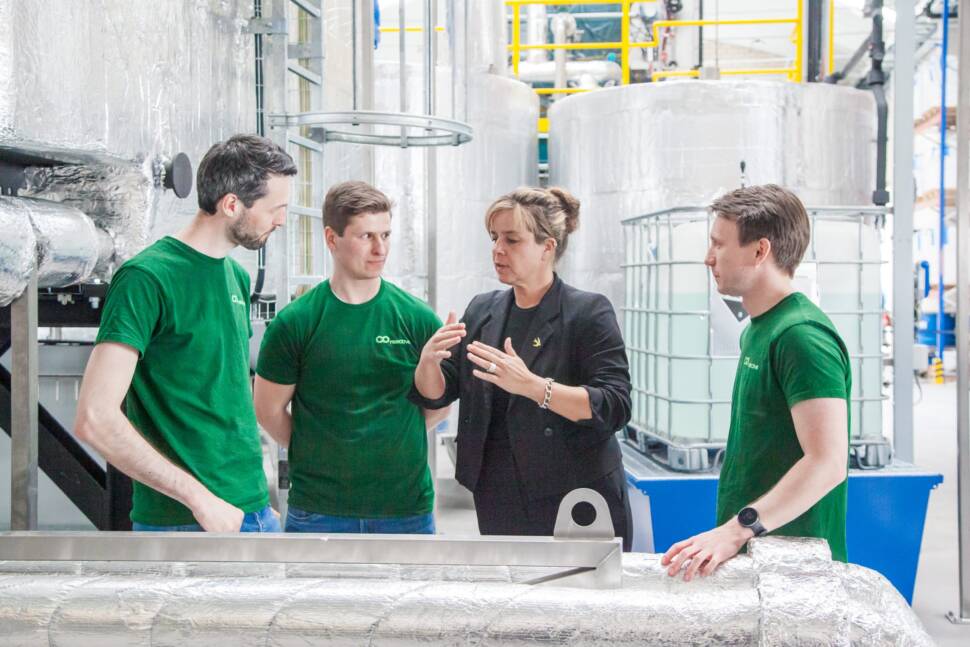 NRW-Wirtschaftsministerin Mona Neubaur im Gespräch mit Co-reactive-Gründern bei der Vorstellung des Baustoffreaktors.