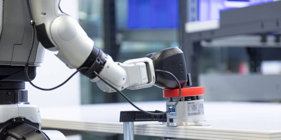 Arm von humanoidem Roboter schlägt auf Tisch