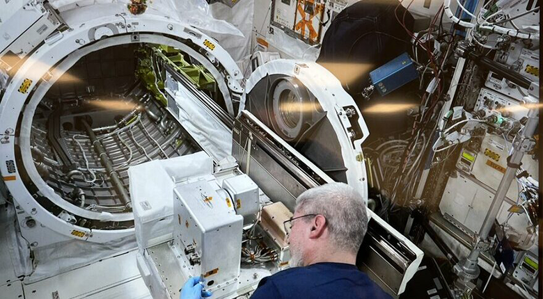 Ein Astronaut testet ein einen Stecker für das Docking von Satelliten auf der Internationalen Raumstation.