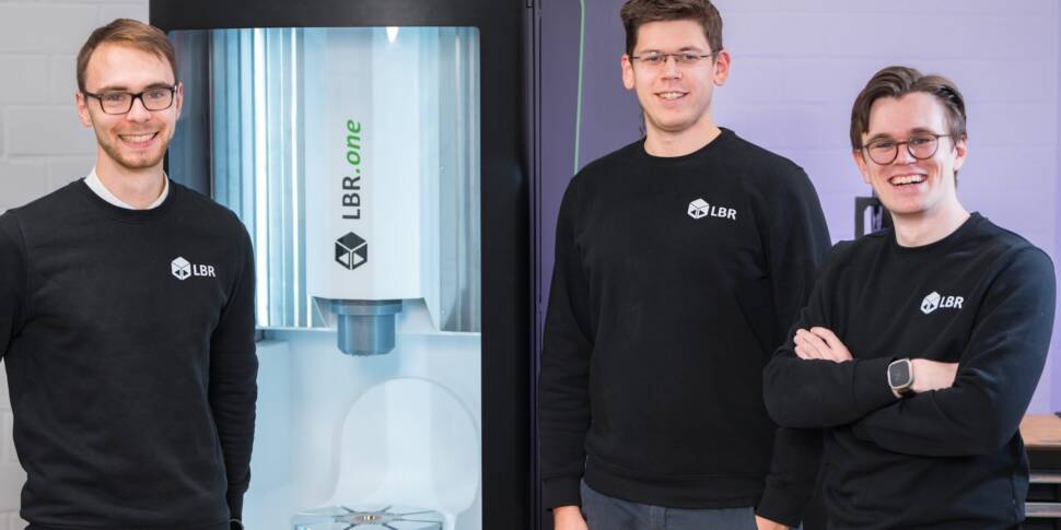 Das Gründerteam sind drei Personen vor der Maschine